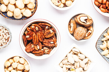 Assortment of fresh dry nuts and seeds on white background top view. healthy vegan food concept.