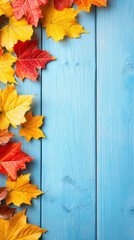 Blue wooden background adorned with fall leaves