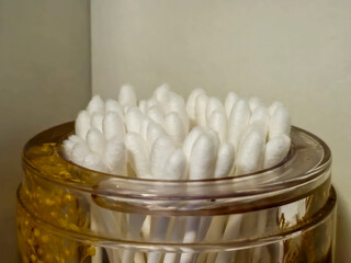 A close-up image of a jar filled with cotton swabs, highlighting their white texture, ideal for personal care and hygiene themes.