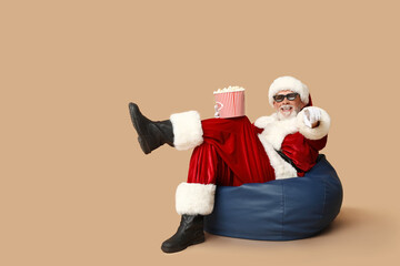 Santa Claus in 3D glasses with bucket of tasty popcorn on brown background