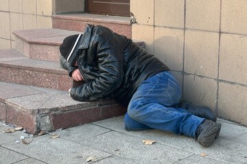 Homeless dirty person lying on the ground in Moscow, Russia