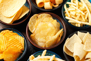 Set of different crispy potato chips in bowls. Snack food
