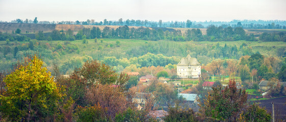 panoramic view to Ukrainian village Sutkivtsy and old fortress-church in central part in autumn day