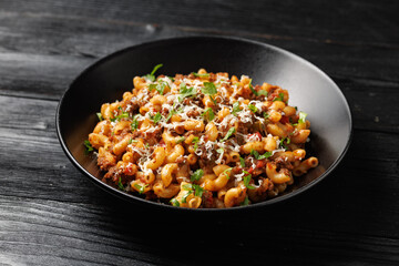 Homemade Taco Beef Pasta in a black bowl. Mexican food.
