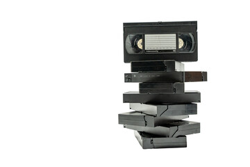 A stack of old VHS tapes on top of each other. The stack is made up of different sizes of tapes, and the top one is the largest. Concept of nostalgia and the idea of preserving memories