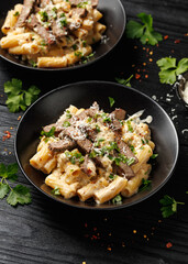 Philly cheese steak pasta in black bowl