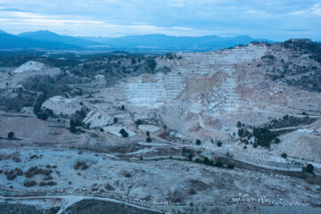 Aerial view of Open-air mining activity in a white marble mine.