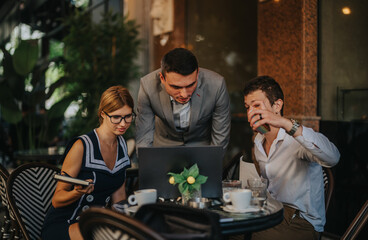 Businesspeople working together in a cafe, using laptops and enjoying coffee. The scene highlights teamwork, collaboration, and productivity in a casual business setting.