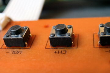 Tactile switches on an electronic circuit board. Tact buttons in a row.