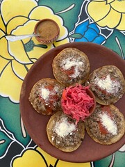 Traditional garnachas served on a clay plate at a restaurant in Oaxaca, Mexico. Deep-fried beef on masa with salsa and cheese. Top View.