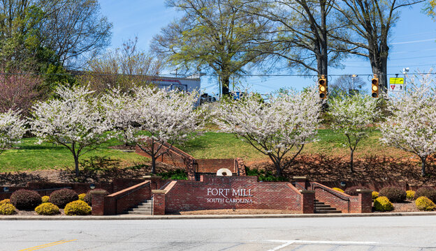 FORT MILL, S.C.-2 APRIL 22: 'Fort Mill' sign on brick wall with blooming dogwoods at entrance to Main St.  Colorful identifier for the town.