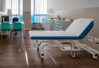 Medical office interior with examination table and doctor's workplace 