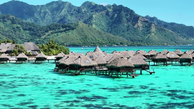 Drone Tahiti. Aerial view of Moorea island lagoon, overwater bungalows in clear ocean water. Luxury honeymoon vacation, romantic getaway. French Polynesia.