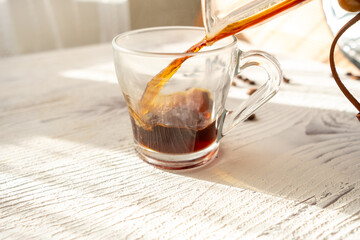 coffee being poured into a glass cup on a white background in slow motion