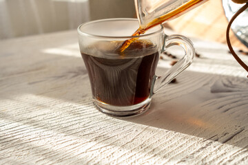 coffee being poured into a glass cup on a white background in slow motion