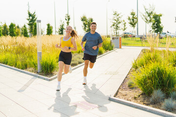 Young Runners Enjoy a Sunny Day Jogging Together in a Park Lined With Greenery and Well-Maintained Walkways