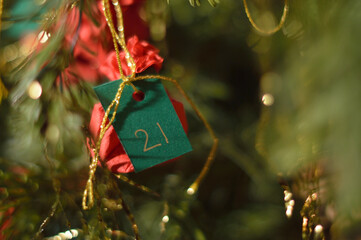 Little red present hanging in the Christmas tree with the number 21 on it.