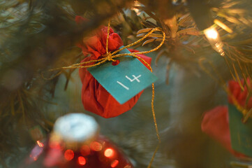 Little red present hanging in the Christmas tree with the number 14 on it.
