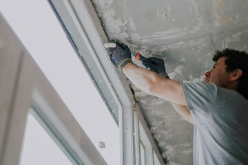 A worker cleans a window frame with a jigsaw.