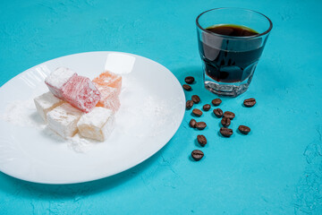 colorful Turkish delights and espresso on a white plate in the cafe