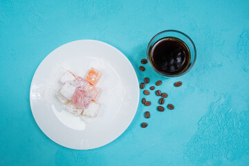 colorful Turkish delights and espresso on a white plate in the cafe