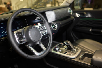 Closeup of a modern car steering wheel with control buttons for technology and convenience