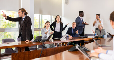 Angry multiracial male and female office colleagues of different age emotionally arguing with each...