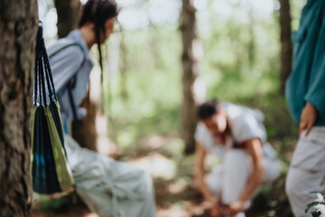 Friends spending a relaxed day in the forest, engaging in conversations, and enjoying the serenity of nature with a hammock.