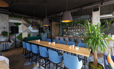 Cute restaurant interior with sofas and wooden tables, no people, disinfection, coronavirus concept, panorama