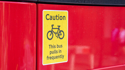 warning sign of bicycles approaching buses, "caution this bus pulls in frequently"