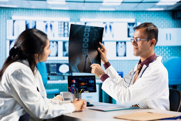 Specialist and patient discussing diagnostic results in a modern medical office, establishing advanced healthcare technology to present x ray imaging results and MRI scans. Care management.