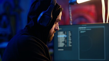 Hacker hiding in bunker removing headphones to hear suspicious sounds, feeling anxious after...