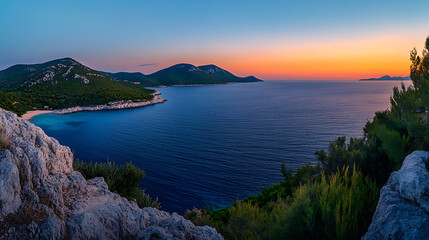 Panoramic view of the sea, sunset with orange and blue sky, green mountains in the distance, blue water surface, panoramic photography