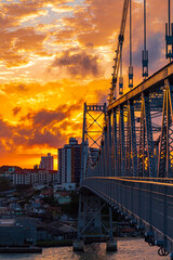 nuvens laranjas e a Florianopolis e a ponte Hercílio Luz no pôr-do-sol Florianópolis Santa...