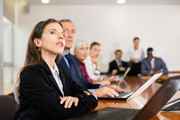 Attentive businesswoman listening to a speaker at a business meeting