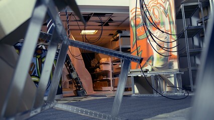 Empty basement with damaged objects and graffiti paint, concept of subversive lifestyle. Criminal...