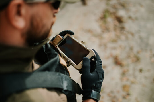 Soldier using mobile phone wearing tactical gloves and gear