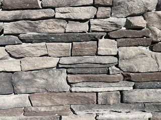 A close-up shot of a stone wall with multiple shades of grey.
