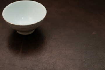 Overhead view of a mini white ceramic bowl on a brown background, Top view of a white ceramic mixing bowl, Flat lay of ceramic batter bowl