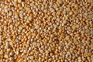 Uncooked Polished Split Peas Background. A Culinary Canvas of Dry Yellow Peas, Creating a Lively and Textured Background for Gourmet Cooking. Scattered Raw Polished Peas. Healthy Eating Ingredients