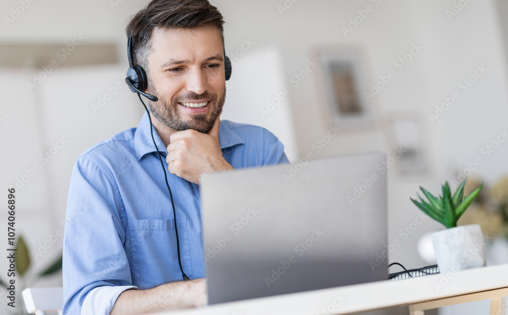 Poster hotline support service. handsome male call center operator in headset working with laptop in modern