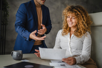male colleague give advice and help female colleague to finish work