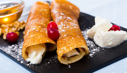 Close up image of delicious pancakes stuffed with young cheese and honey