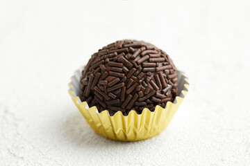Typical Brazilian sweet brigadeiro. One chocolate candy on a white background
