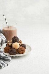 Typical Brazilian sweet brigadeiro. A heap of assorted flavors of candies on a white table