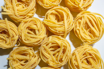 Uncooked Egg-Based Fettuccine Pasta: A Culinary Canvas of Ribbon-Shaped Macaroni, Creating a Lively...
