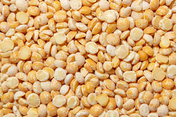 Uncooked Polished Split Peas Background. A Culinary Canvas of Dry Yellow Peas, Creating a Lively and Textured Background for Gourmet Cooking. Scattered Raw Polished Peas. Healthy Eating Ingredients