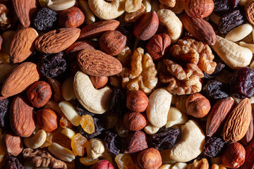 Mixed Nuts: Almonds, Walnuts, Cashews, Peanuts, Hazelnuts, Dried Prunes and Raisins. Different Nut Mix. Background from Various Nuts and Dried Fruits