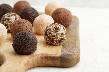 Typical Brazilian sweet brigadeiro. Assorted flavors of candies on a wooden board