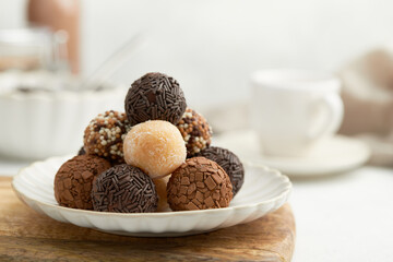 Typical Brazilian sweet brigadeiro. A heap of assorted flavors of candies on a wooden board